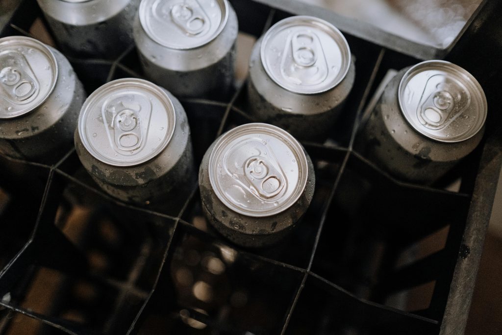 Top-down photo of aluminum beverage cans with condensation in a crate.